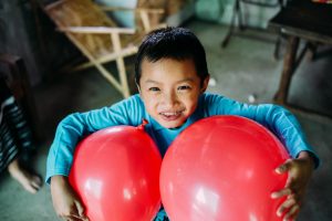 A Boy with two red balloons