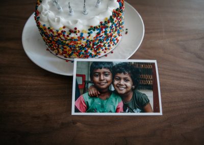 A Cake on a table with a picture of two smiling children.