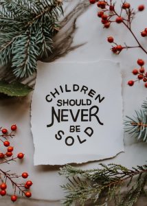 A sign that reads "Children Should Never Be Sold"