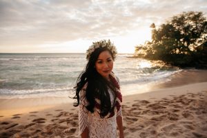 Nhu wearing a wedding dress while on a beach.