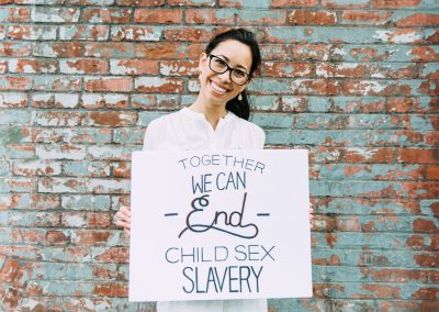 A Girl Holding a sign that says "Together We Can End Child Sex Slavery"