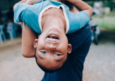 A young boy smiling while being lifted up.