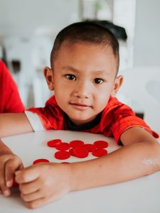 A young boy playing with checkers.