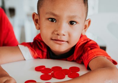 A young boy playing with checkers.