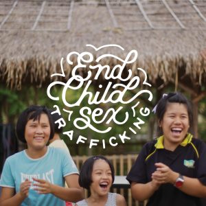 Three smiling girls next to text that reads "End Child Sex Trafficking"