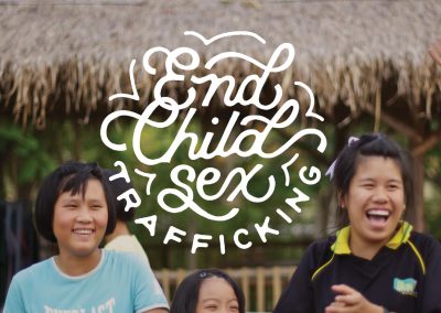 Three smiling girls next to text that reads "End Child Sex Trafficking"