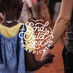 Two people holding hands by some text that reads "End Child Sex Trafficking"