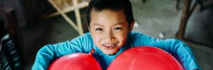 A boy holding two red balloons